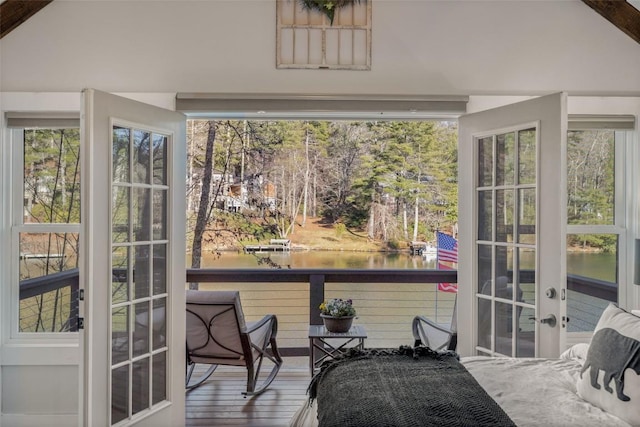 sunroom / solarium with french doors, a water view, and vaulted ceiling