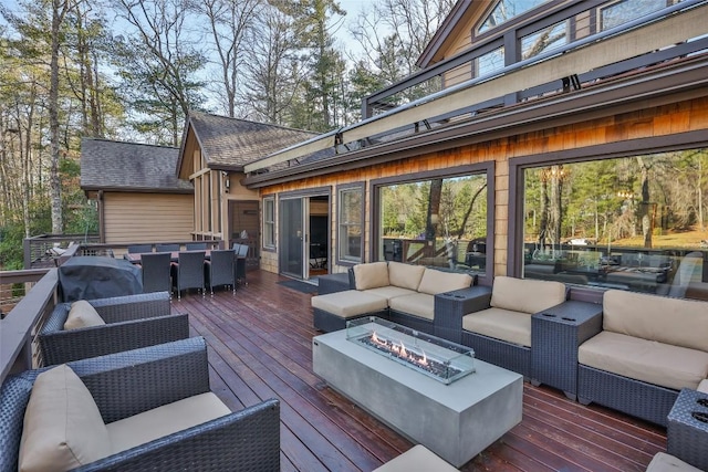 deck featuring outdoor dining area and an outdoor living space with a fire pit