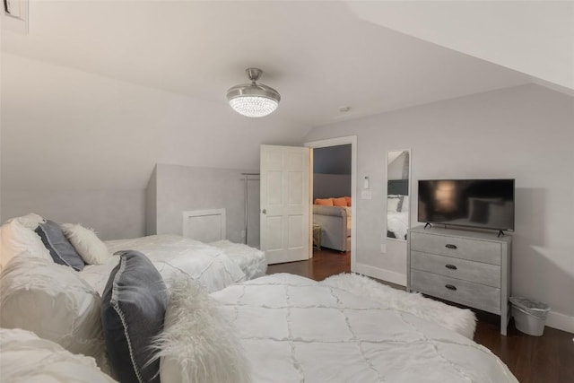 bedroom featuring vaulted ceiling, baseboards, and wood finished floors