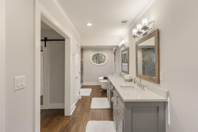 bathroom featuring wood finished floors, a sink, visible vents, and crown molding