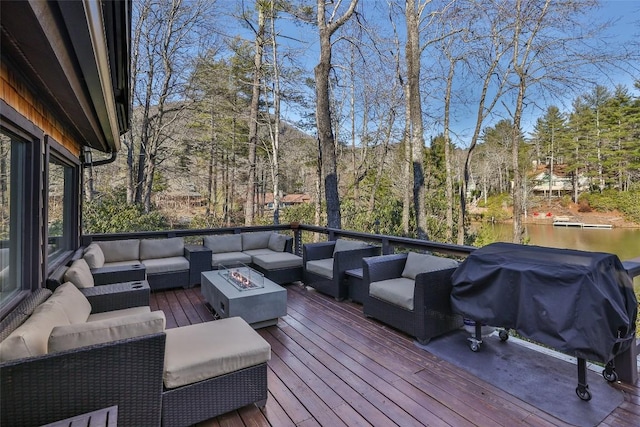 wooden deck with grilling area and an outdoor living space with a fire pit