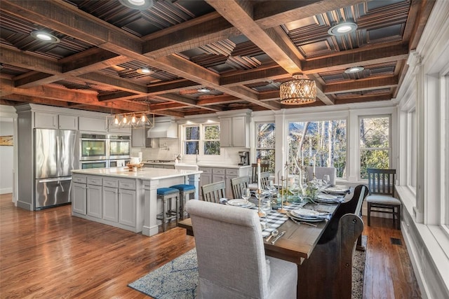 interior space with dark wood-style floors, coffered ceiling, and beam ceiling