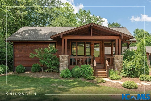 view of front of house with a porch, roof with shingles, and a front lawn