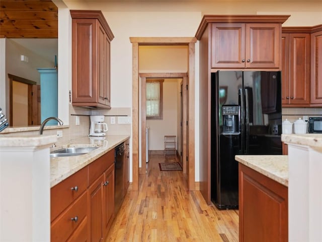 219 Hiwassee Rd, Lake Toxaway, NC 28747 - kitchen with black appliances, backsplash, light wood finished floors, and light stone countertops