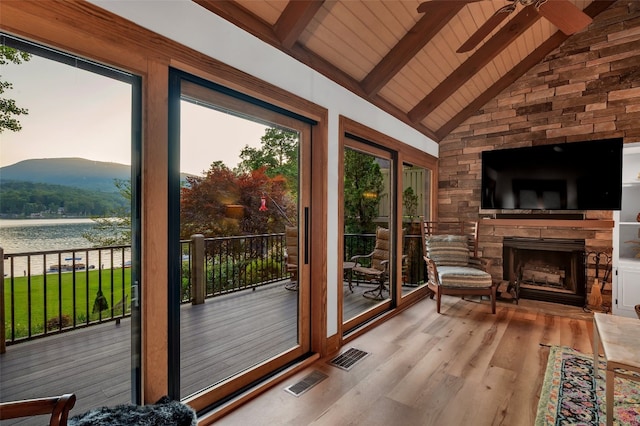 35 Toxaway Landing Dr, Lake Toxaway, NC 28747 - doorway with a ceiling fan, wood ceiling, wood finished floors, a stone fireplace, and a water and mountain view