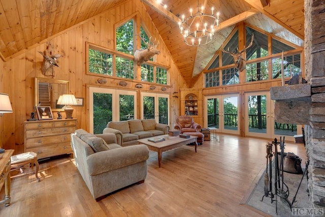 living room featuring an inviting chandelier, light hardwood / wood-style floors, high vaulted ceiling, and wooden ceiling