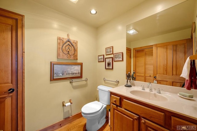 bathroom featuring vanity, wood-type flooring, and toilet