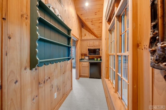 hallway with lofted ceiling, wooden walls, light carpet, and wood ceiling