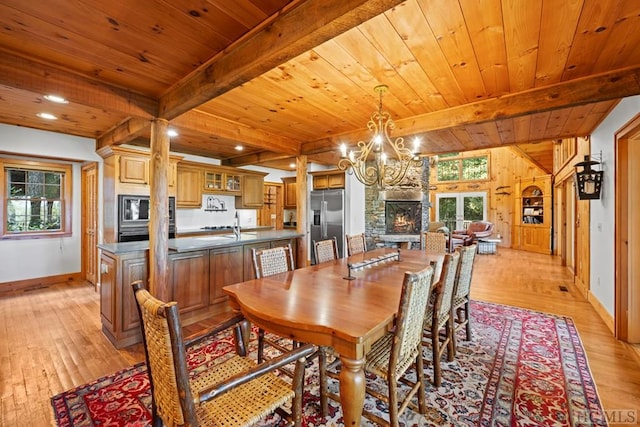 dining space featuring beamed ceiling, wooden ceiling, an inviting chandelier, and light hardwood / wood-style flooring