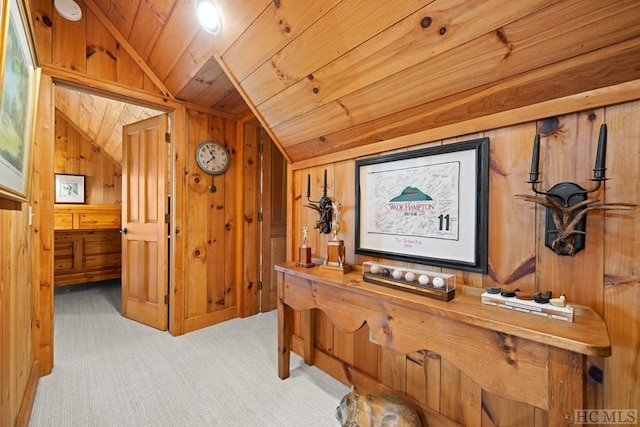 hallway with lofted ceiling, wooden walls, light carpet, and wood ceiling