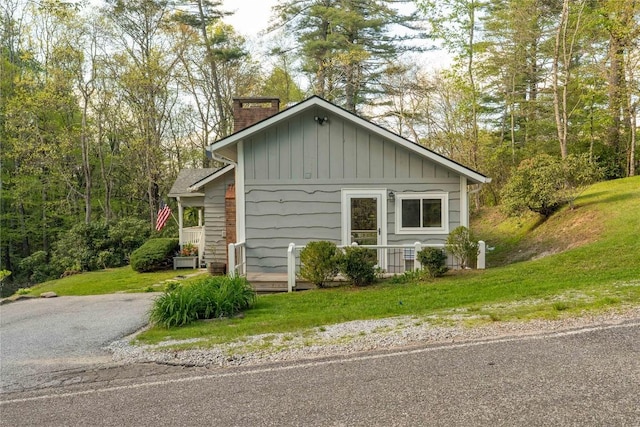 view of home's exterior with a chimney and a lawn