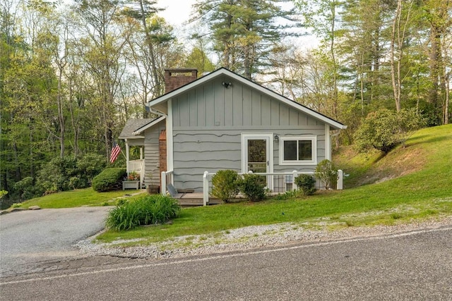 view of side of home with a chimney and a yard