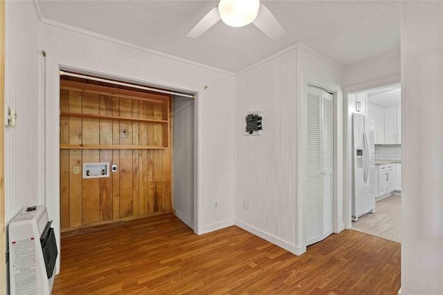 foyer entrance with light wood finished floors, a ceiling fan, and heating unit