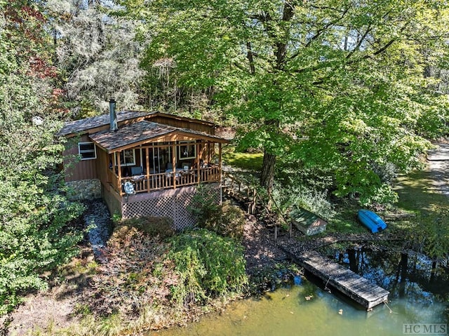 rear view of house featuring a deck with water view