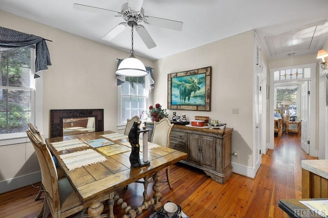 dining space featuring ceiling fan, a fireplace, and wood-type flooring