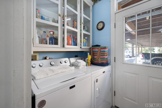 clothes washing area with cabinets and washer and dryer