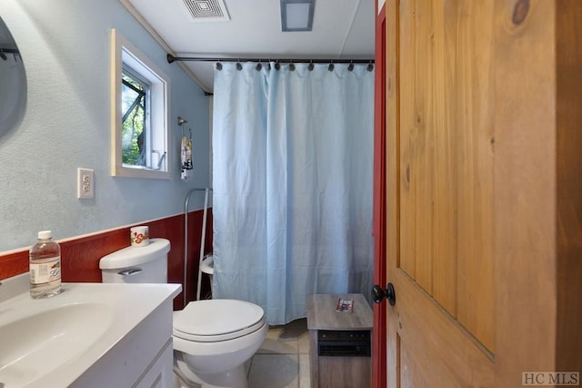 bathroom featuring vanity, tile patterned flooring, toilet, and walk in shower