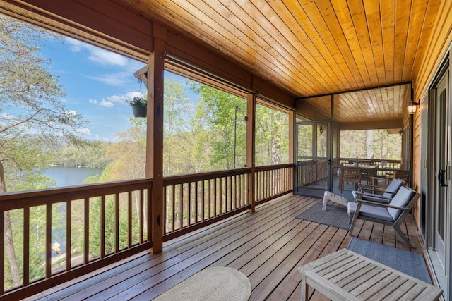 sunroom featuring a water view