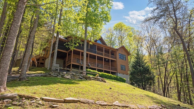 back of property with a yard, a deck, and stairway