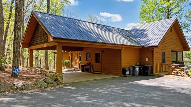view of front of house with asphalt driveway, metal roof, and a carport
