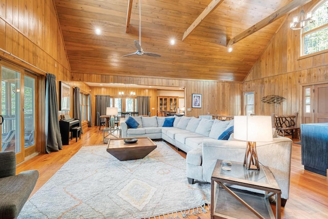 living area featuring high vaulted ceiling, wooden ceiling, wooden walls, a chandelier, and light wood-style flooring