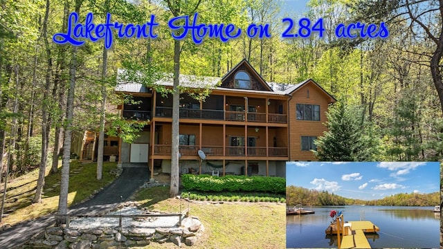 rear view of property featuring a water view and a forest view