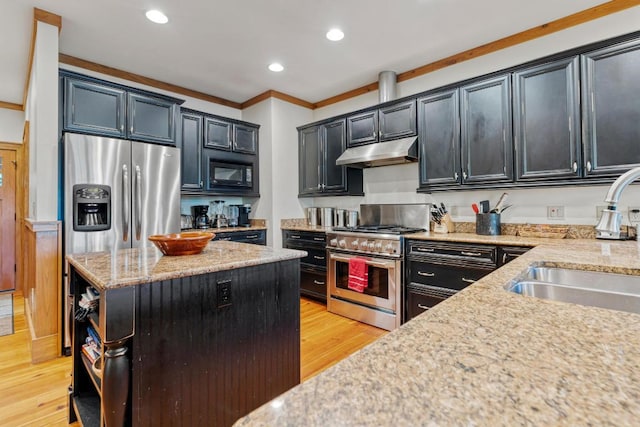 kitchen featuring under cabinet range hood, stainless steel appliances, a sink, light wood-style flooring, and crown molding