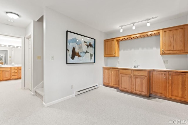 kitchen with a baseboard radiator, sink, and light carpet