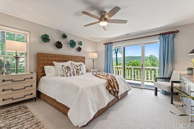 bedroom featuring multiple windows, access to exterior, and ceiling fan