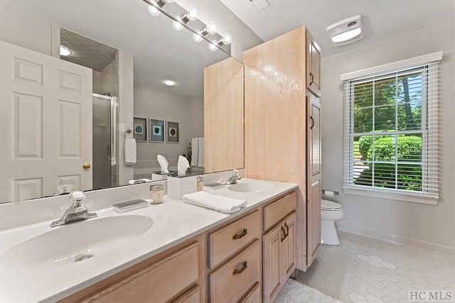 bathroom with an enclosed shower, vanity, tile patterned floors, and toilet