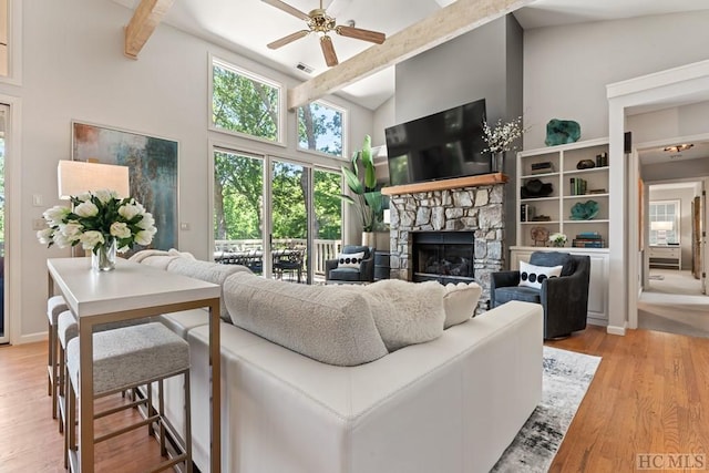 living room with high vaulted ceiling, a fireplace, light hardwood / wood-style floors, and ceiling fan