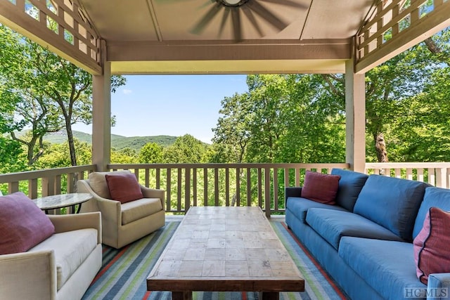 deck with ceiling fan and an outdoor living space