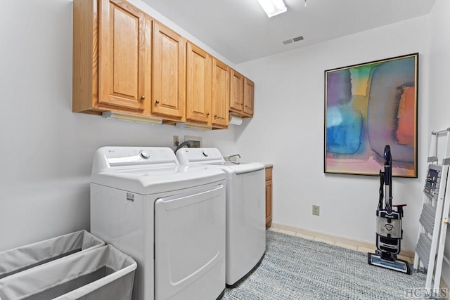 laundry area with cabinets, light tile patterned floors, and independent washer and dryer