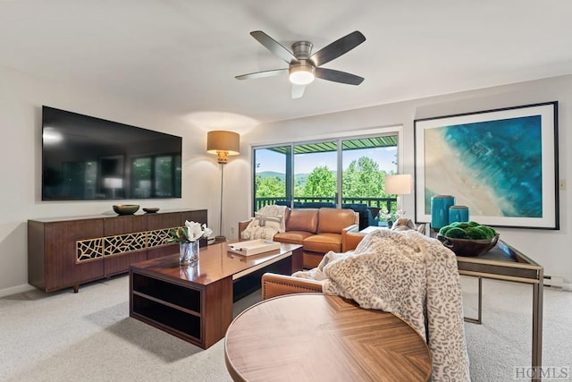 carpeted living room with ceiling fan