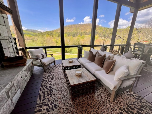 sunroom featuring a view of trees and an outdoor living space