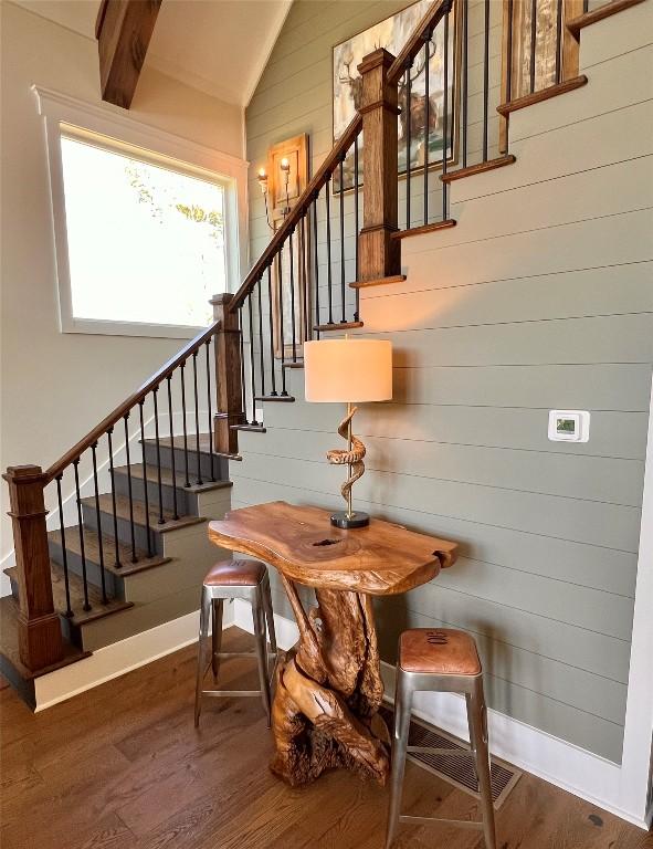 staircase with baseboards, wood finished floors, and lofted ceiling