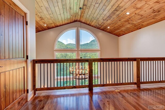 interior space featuring hardwood / wood-style flooring, a mountain view, and wood ceiling