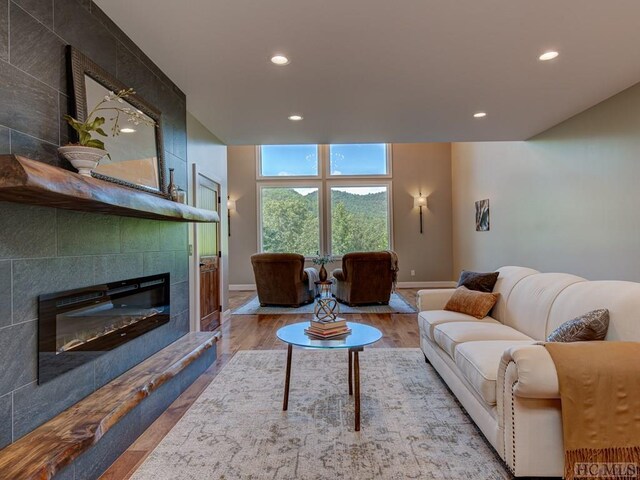 living room featuring a tile fireplace and hardwood / wood-style floors