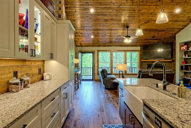 kitchen with white cabinets, a sink, a ceiling fan, open floor plan, and wooden ceiling