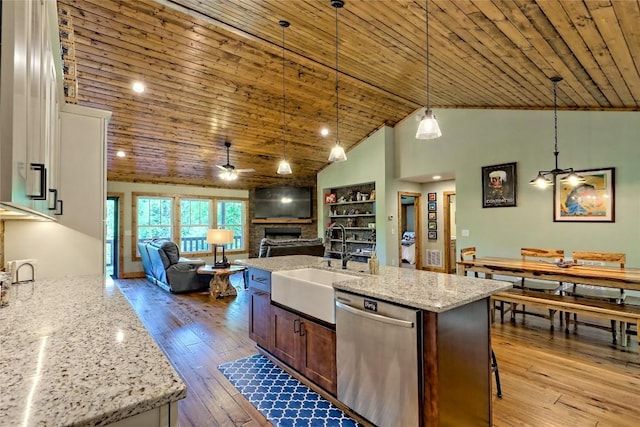 kitchen featuring a sink, dishwasher, a large fireplace, hardwood / wood-style floors, and a ceiling fan