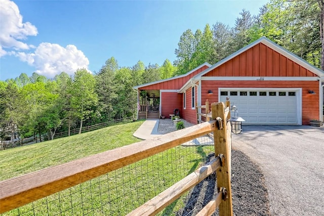 view of front of house with fence private yard, a garage, a front yard, board and batten siding, and driveway