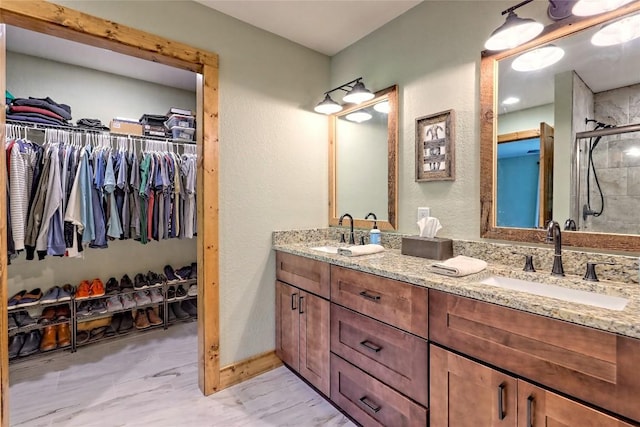 full bath with double vanity, a walk in closet, and a sink