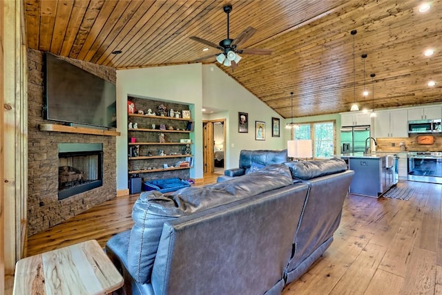 living area with light wood-style floors, wood ceiling, ceiling fan, and a stone fireplace