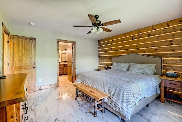 bedroom featuring ceiling fan, wood walls, and connected bathroom