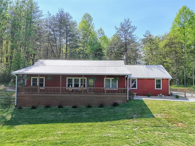 ranch-style home featuring a porch, metal roof, and a front yard