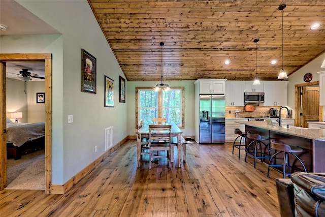 dining area with visible vents, baseboards, wooden ceiling, and hardwood / wood-style flooring