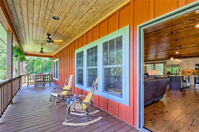 deck featuring a ceiling fan and a sink