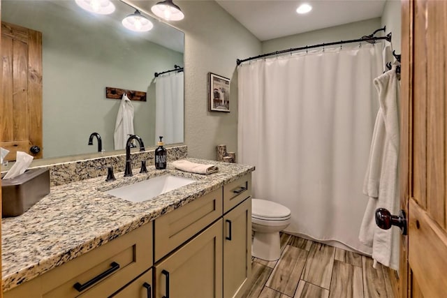 bathroom with vanity, toilet, and wood finished floors