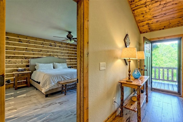 bedroom with vaulted ceiling, baseboards, wood-type flooring, access to outside, and a textured wall