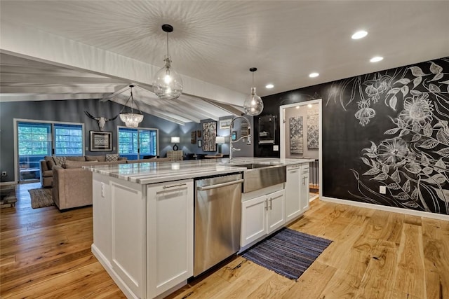 kitchen featuring white cabinets, open floor plan, light wood-style floors, stainless steel dishwasher, and vaulted ceiling with beams